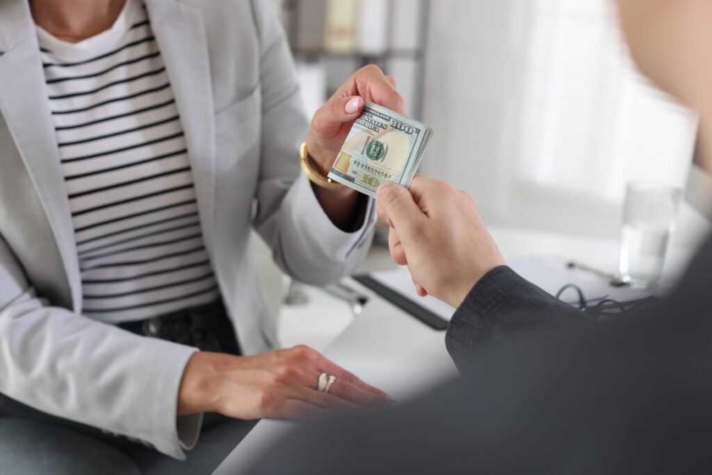 bonus. boss giving money to employee in office, closeup